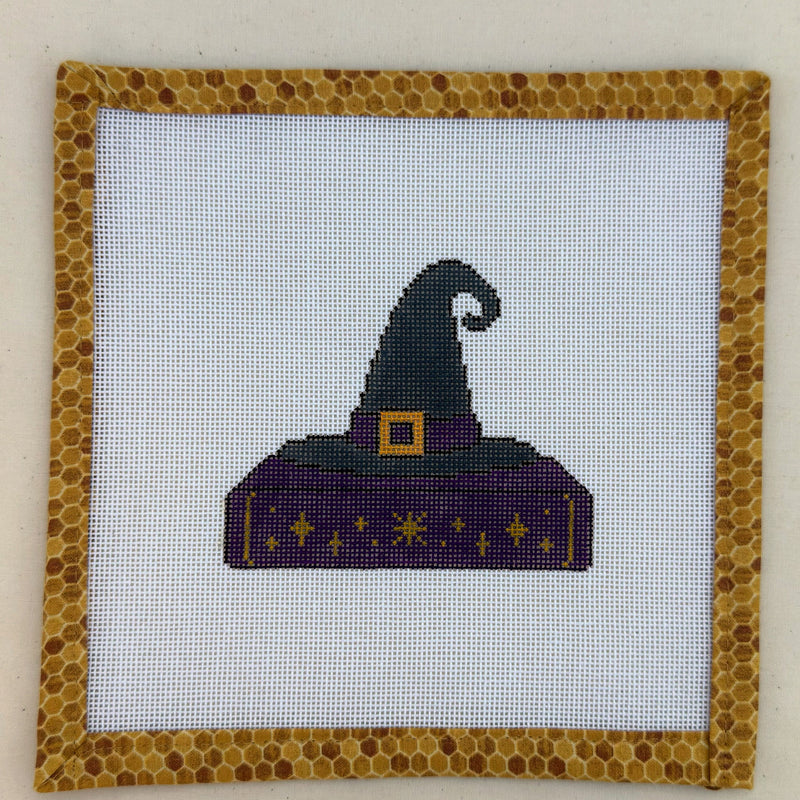 Hand-painted needlepoint canvas of a purple and charcoal witch's hat with a gold buckle